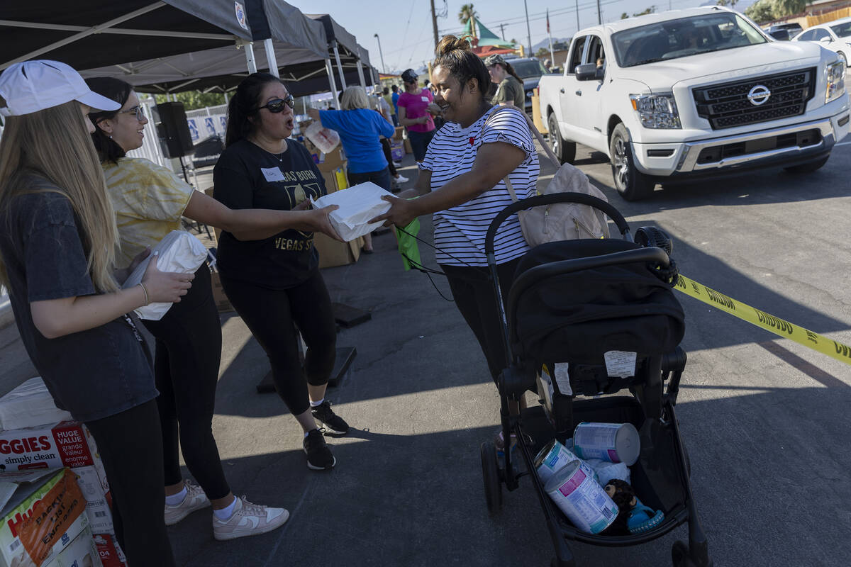 Marilyn Tapia picks up diapers during a baby supply giveaway put on by HELP of Southern Nevada ...