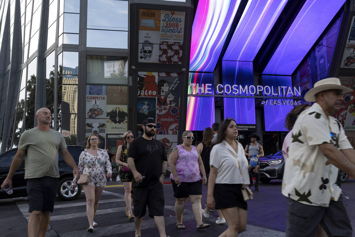 Pedestrians walk along Las Vegas Boulevard outside The Cosmopolitan, Wednesday, June 8, 2022, o ...