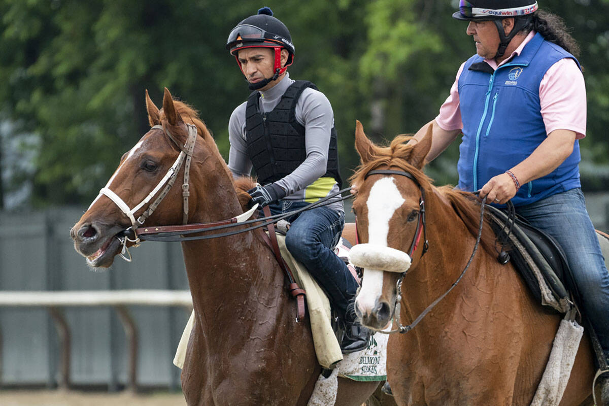 Rich Strike, left, walks off the track after training before the 154th running of the Belmont S ...