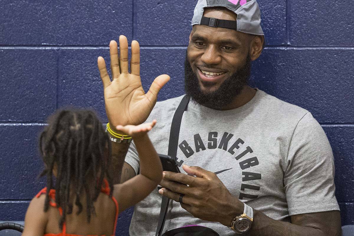 Los Angeles Lakers power forward LeBron James high fives his daughter Zhuri before the start of ...