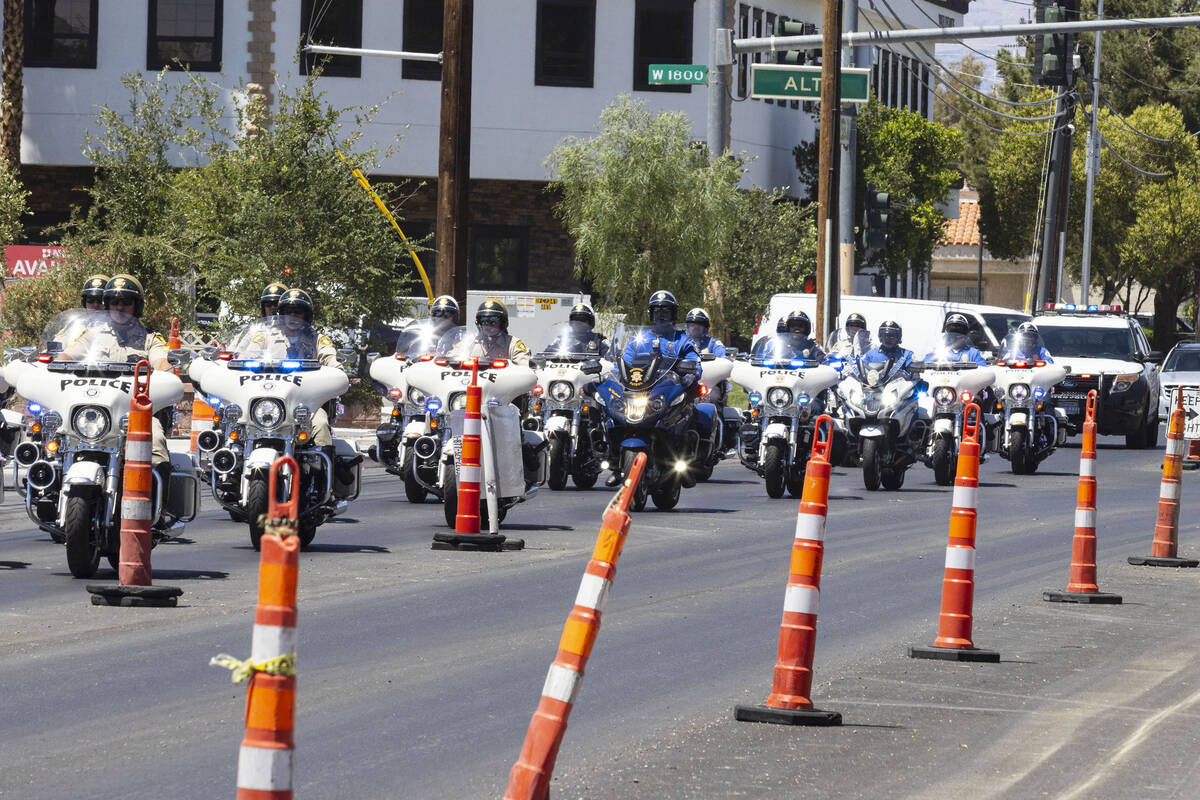 Las Vegas police cars and motorcycles escort the body of a Metro police officer, killed after a ...