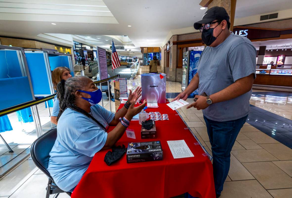 The Clark County Election Department's Johnita Johnson, left, assists Brandon Sermeno of Las Ve ...