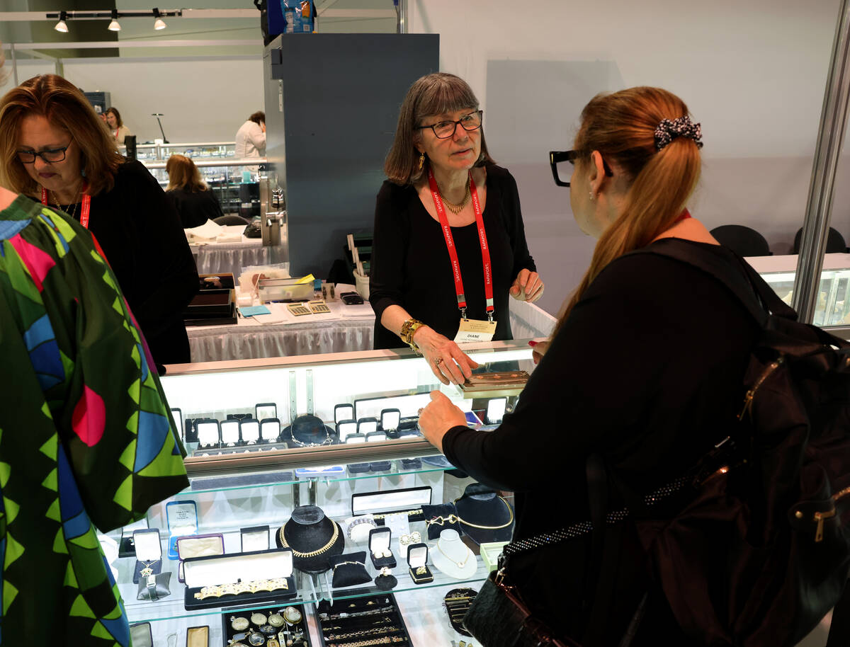 Pam Benson of Palos Heights, Ill., left, shows jewelry to Shawn Rosler of Gem de la Gem in Bogo ...