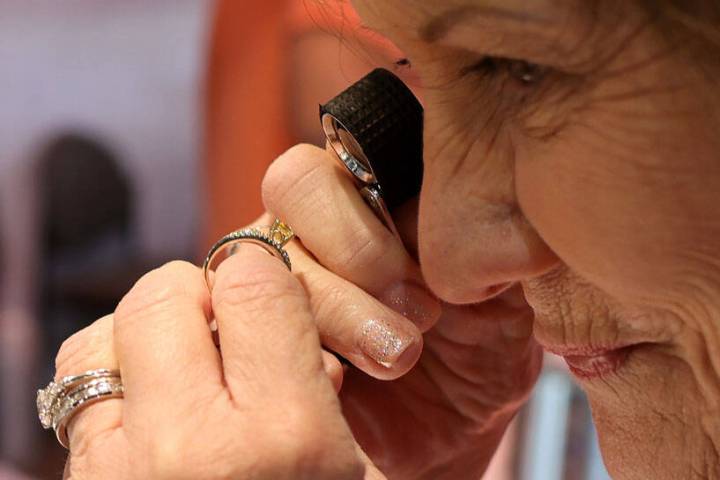 Joyce Gahn of Gems by Joyce in Sun City, Ariz. uses a jewelry loupe to check out a ring during ...