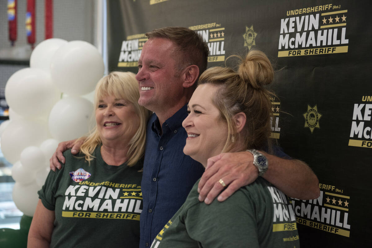 Kevin McMahill, center, poses with family friends Gay Gustafson, left, and Kelly Young, right, ...