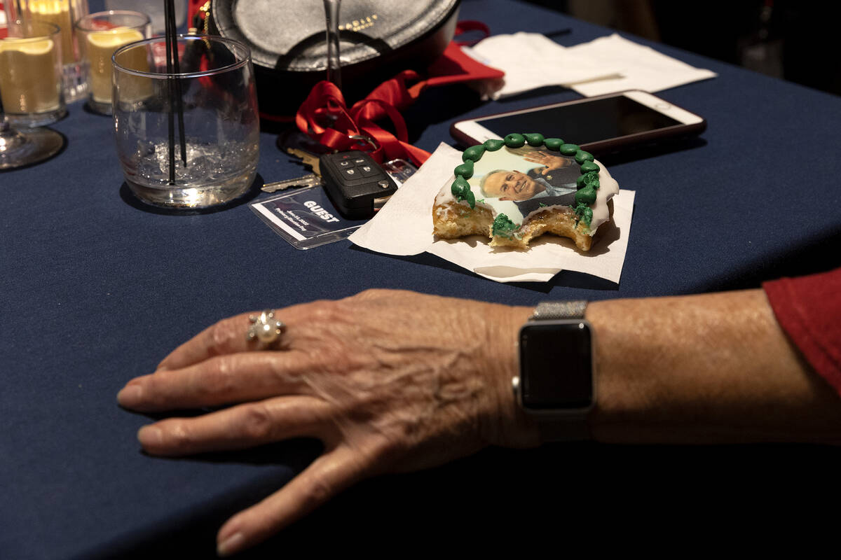 A guest chats while eating a doughnut with the face of Republican candidate for Nevada governor ...