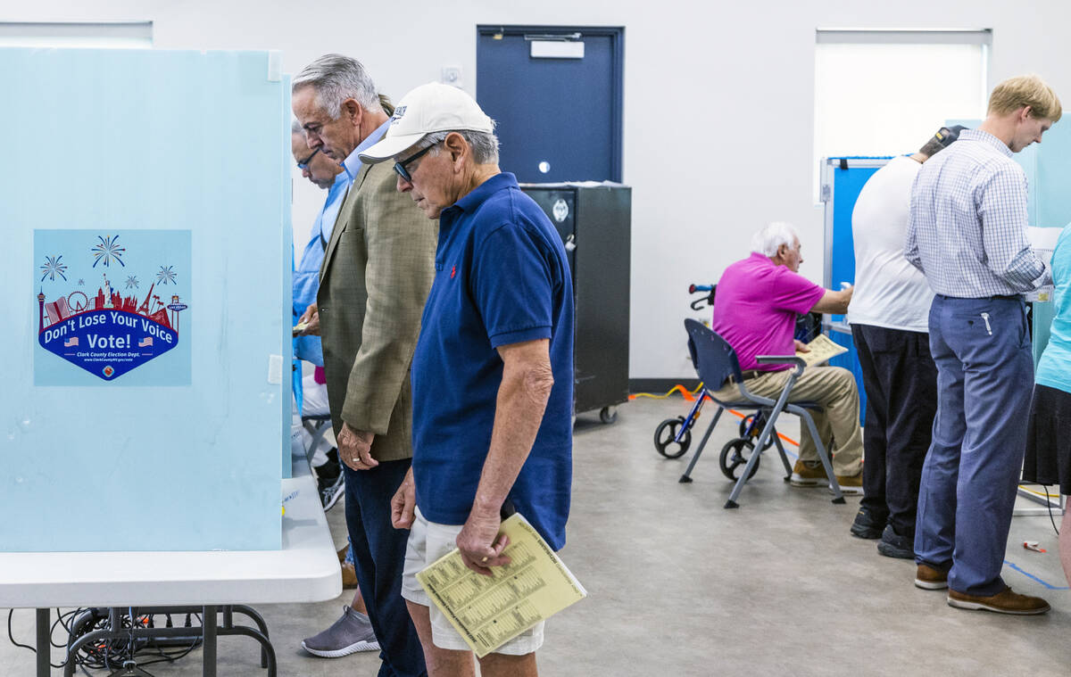 Sheriff Joe Lombardo, left, joins others as they cast their votes during the Nevada primary ele ...