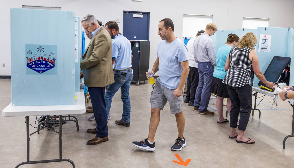 Sheriff Joe Lombardo, left, joins others as they cast their votes during the Nevada primary ele ...