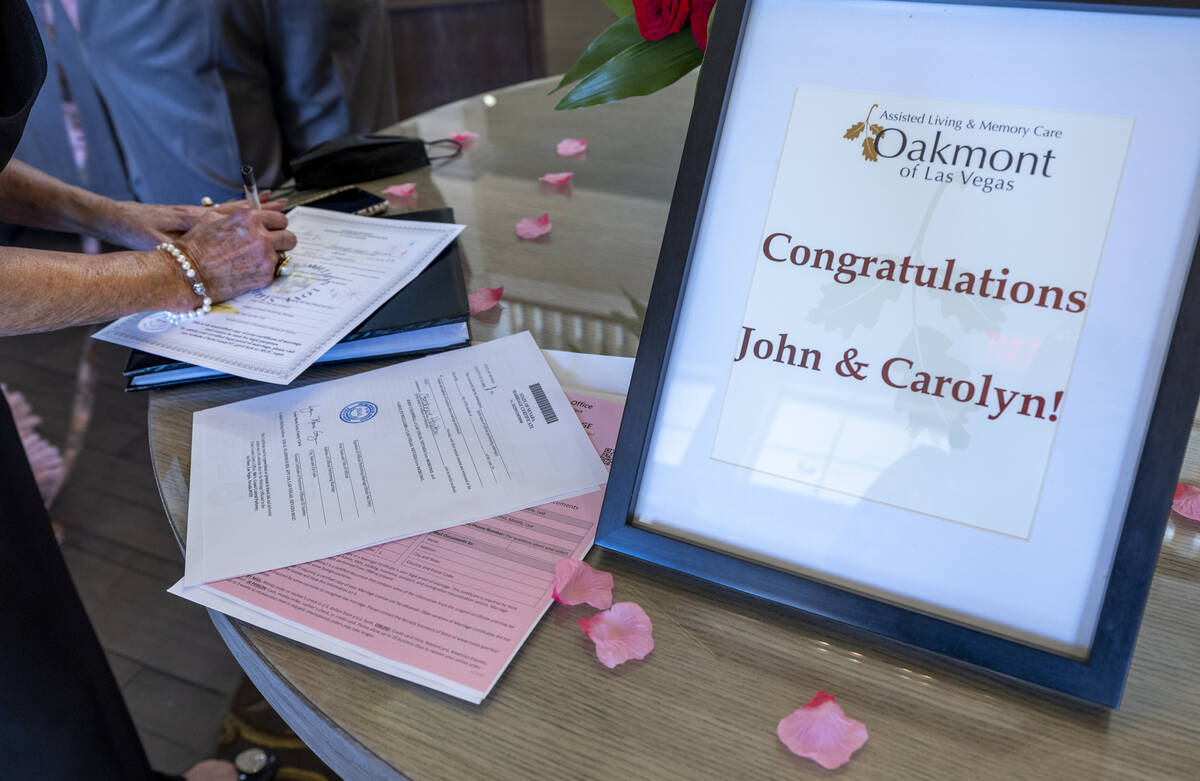 The Reverend Judy Irving with Wedding Vows Las Vegas prepares the wedding certificate for groom ...