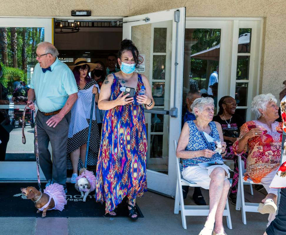 Groom John Hansell, left, walks outside with his two dogs Libby, bottom left, and Teddy as his ...