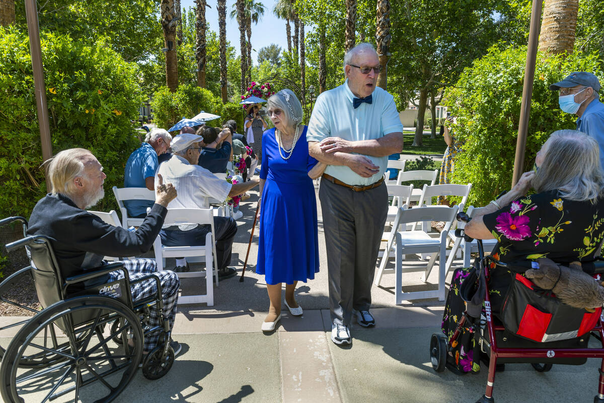 Bride Carolyn Brylinski, center, walks back down the aisle with groom John Hansell, right, to c ...