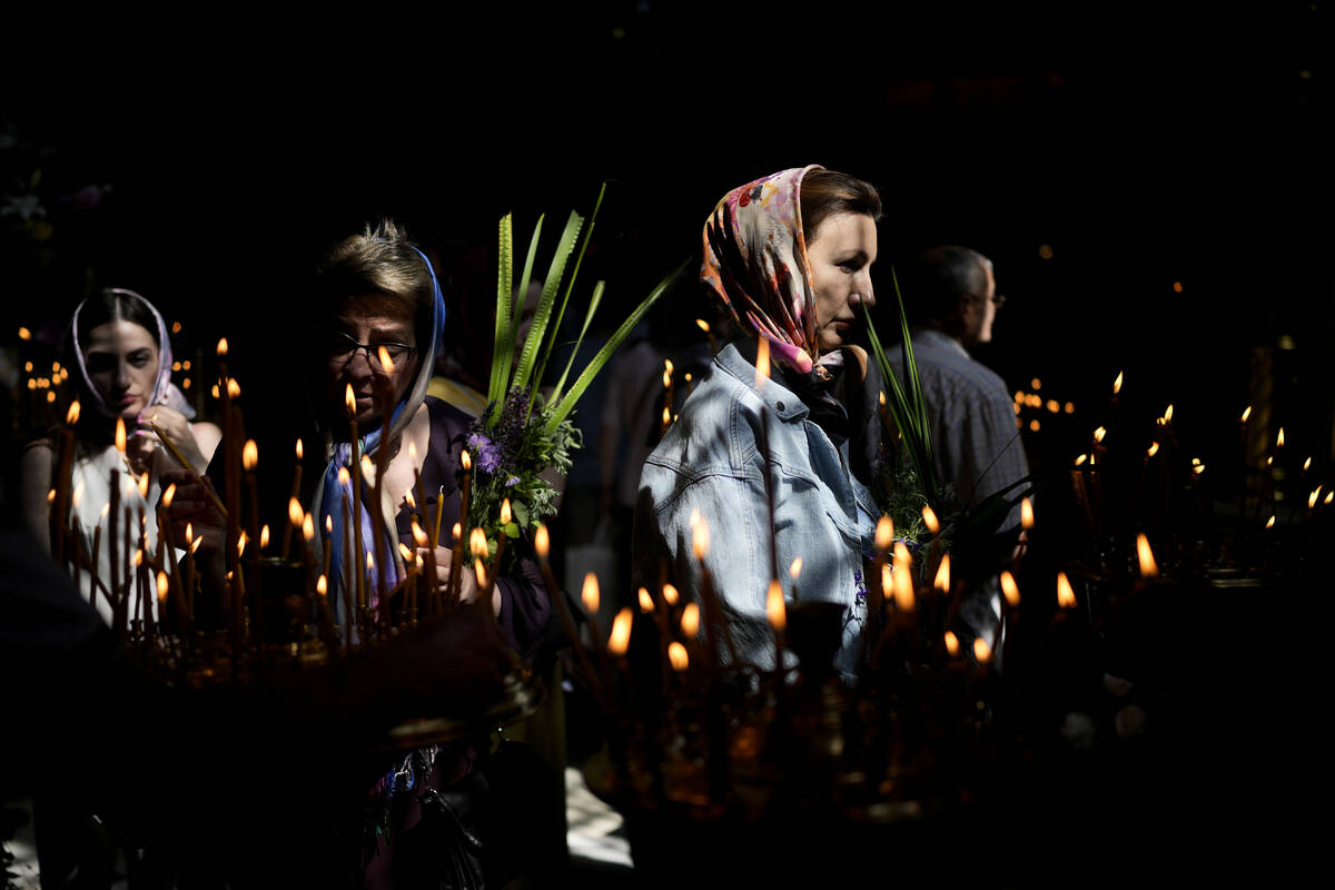 Women attend a mass at St. Volodymyr's Cathedral during Orthodox Pentecost in Kyiv, Ukraine, Su ...