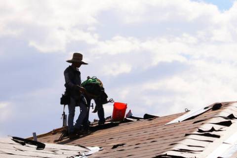 Construction workers labor on rooftops in sweltering heat at the Coronado Condominiums in Summe ...