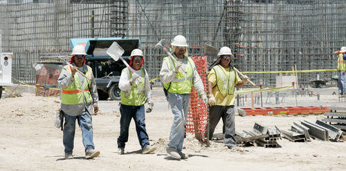 File photo: Construction workers walk off the job site following their shift at a project at Ca ...