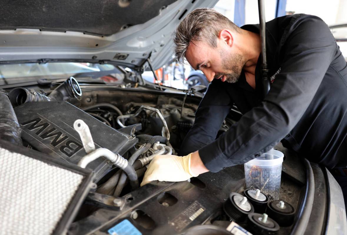 Victor Botnari, owner of Universal Motorcars in Las Vegas, replaces belts and a pulley on a car ...