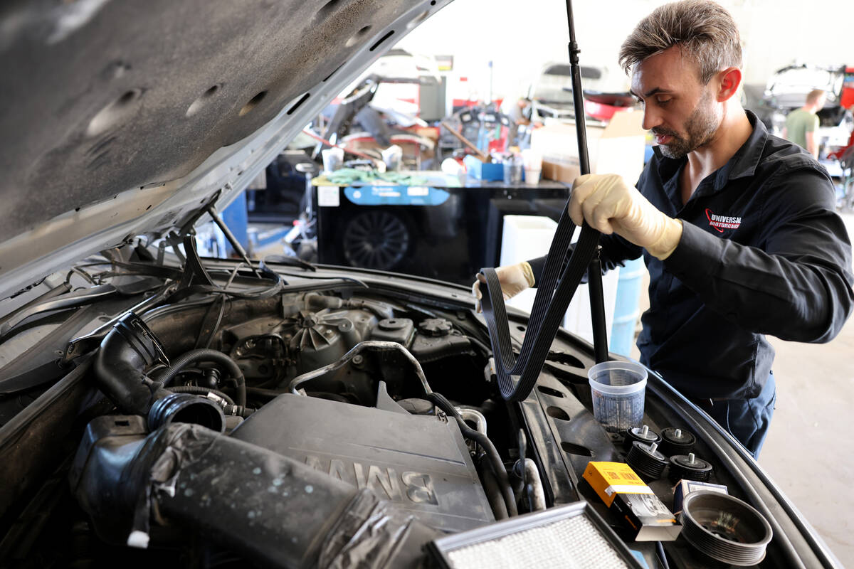 Victor Botnari, owner of Universal Motorcars in Las Vegas, replaces belts and a pulley on a car ...