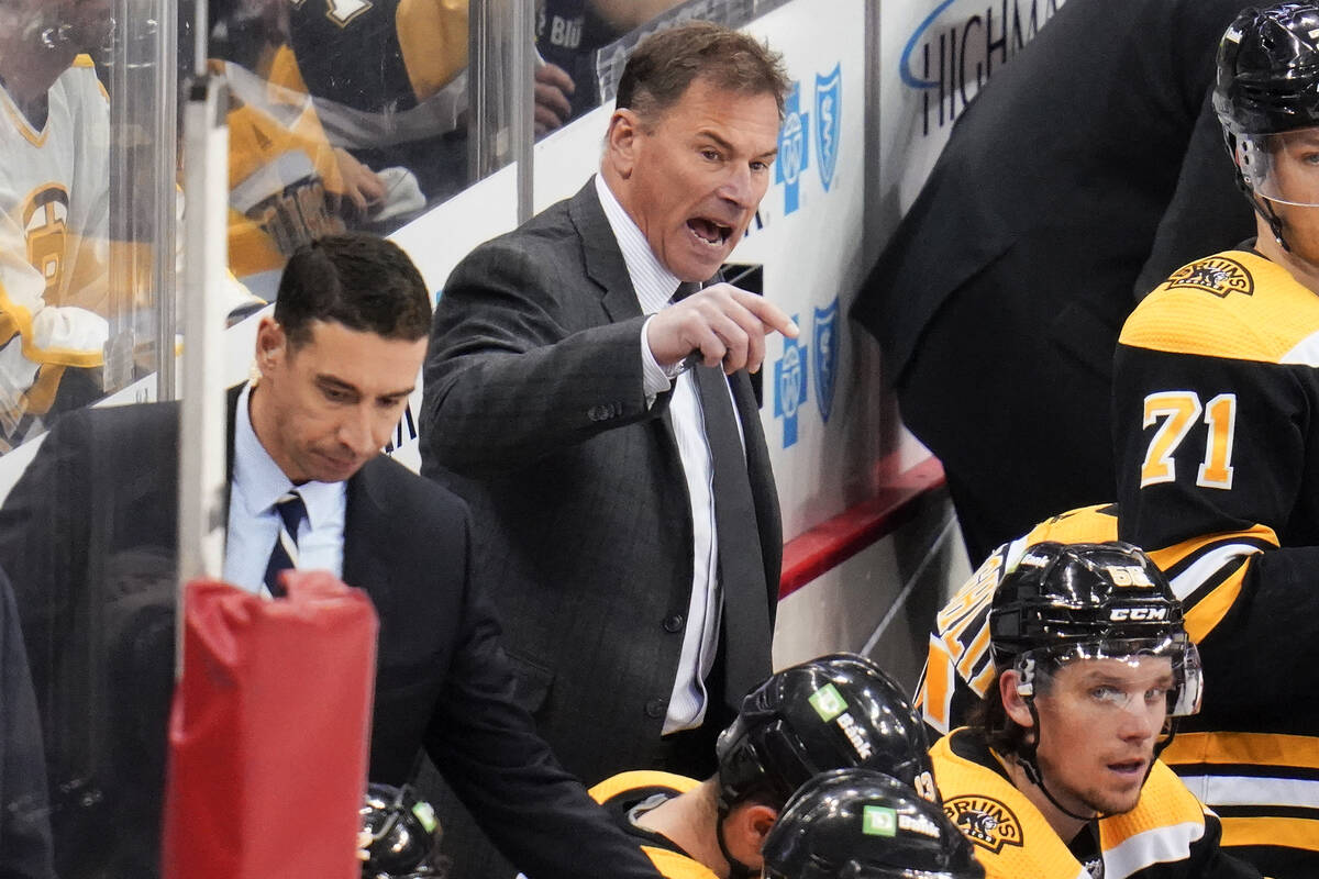 Boston Bruins head coach Bruce Cassidy, center, give instructions during the third period of an ...