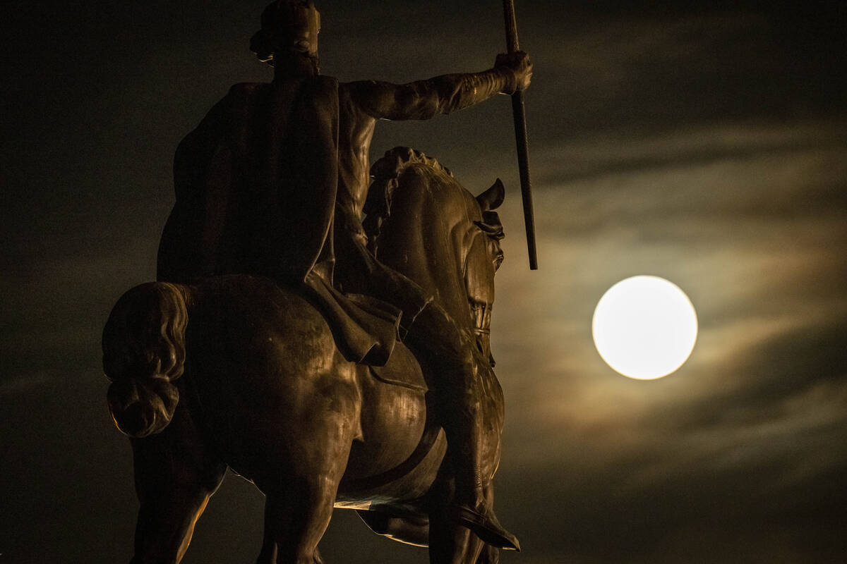 A supermoon rises behind sculpture of Tomislav of Croatia, the first Croatian king, in downtown ...