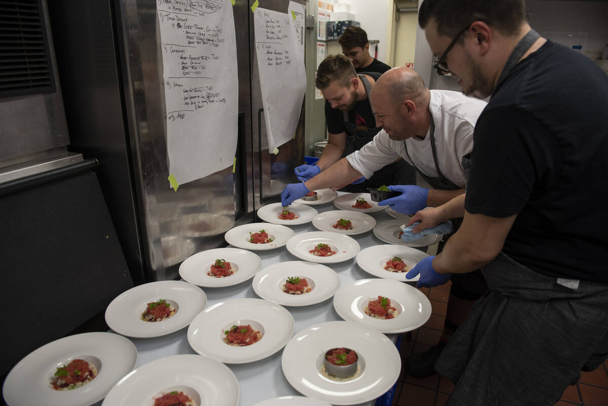 Chef Jeffrey Weiss, center, garnishes the first dish, a tuna tartare with crab, watermelon gran ...