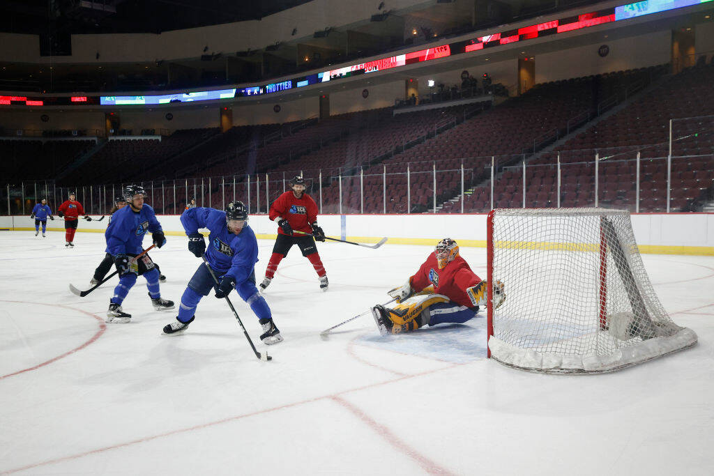 Bobby Farnham of Team B shoots against Brendan Bonello of Team A during a 3ICE Hockey tryout se ...