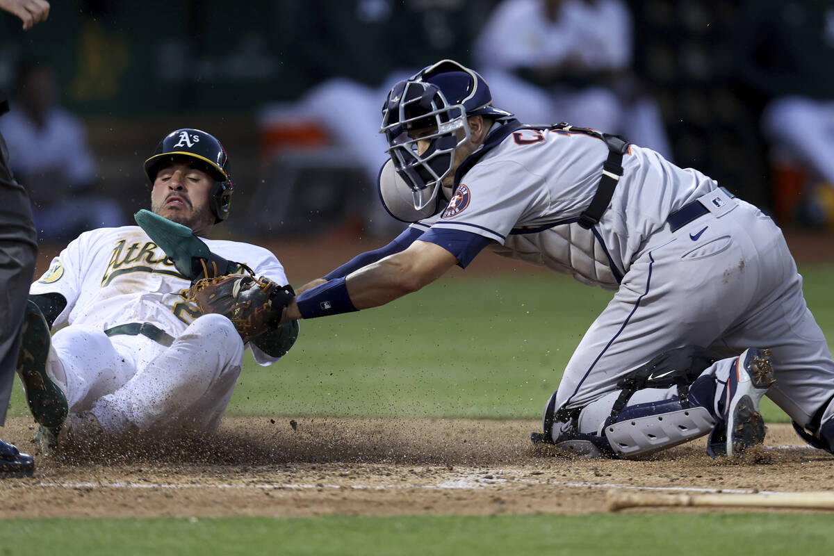 Oakland Athletics' Ramon Laureano, left, is tagged out by Houston Astros catcher Jason Castro, ...