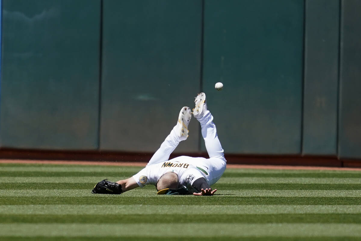 Oakland Athletics left fielder Seth Brown cannot catch a triple hit by Kansas City Royals' Mich ...