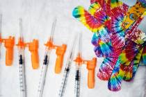 FILE - Syringes and colorful bandages are prepared as children from local schools prepare to ge ...