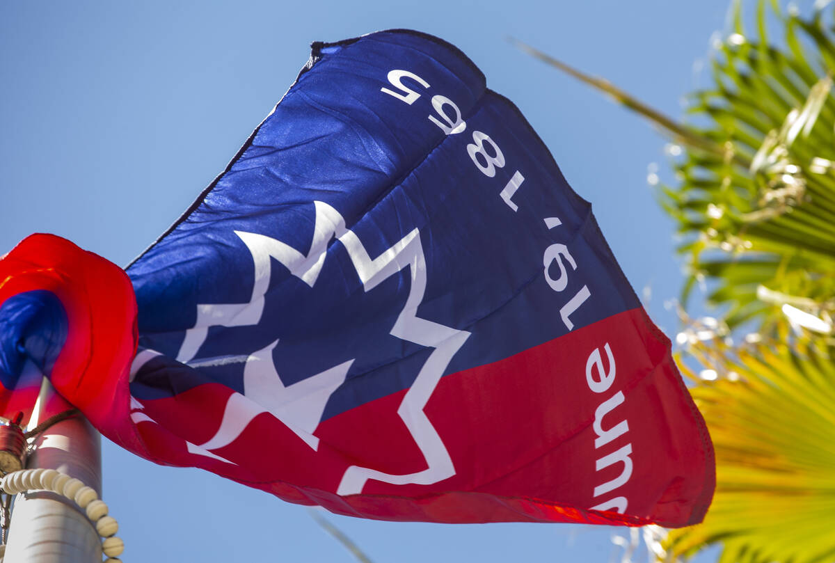 The Juneteenth Independence Day flag begins to flutter after its presentation during a flag pre ...