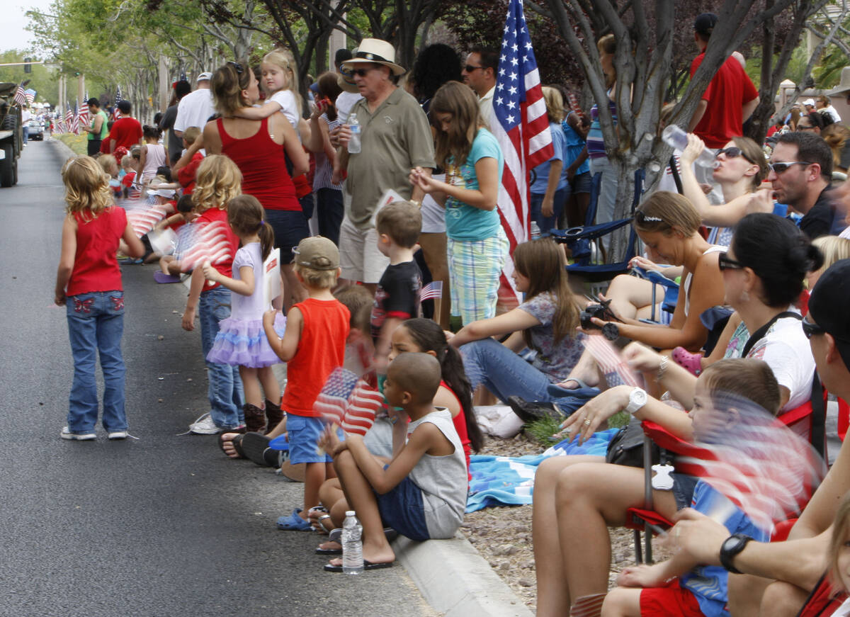 Parade watchers wave American flags at the 2012 Summerlin Council Patriotic Parade in Summerlin ...