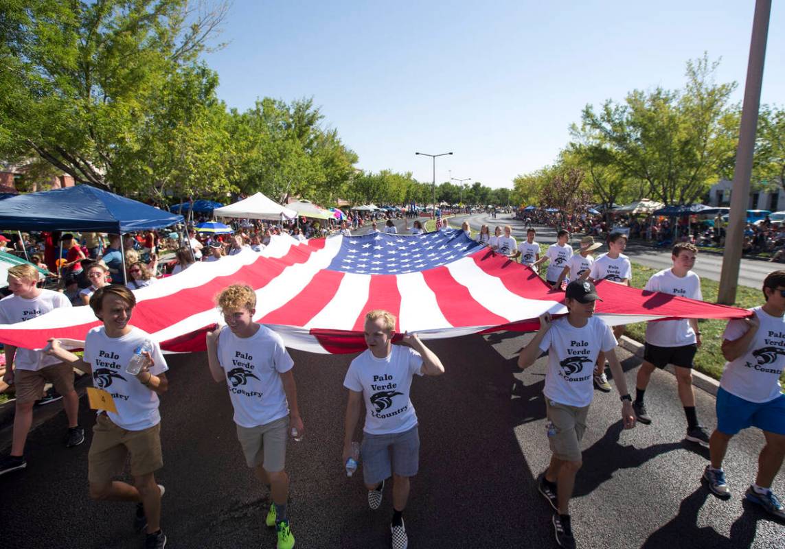 Members of the Palo Verde High School track team march with a giant American flag during the 20 ...