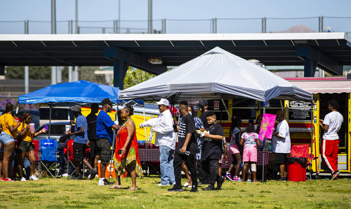 People check out vendors during a Juneteenth event held by Save Our Sons at Lorenzi Park in Las ...