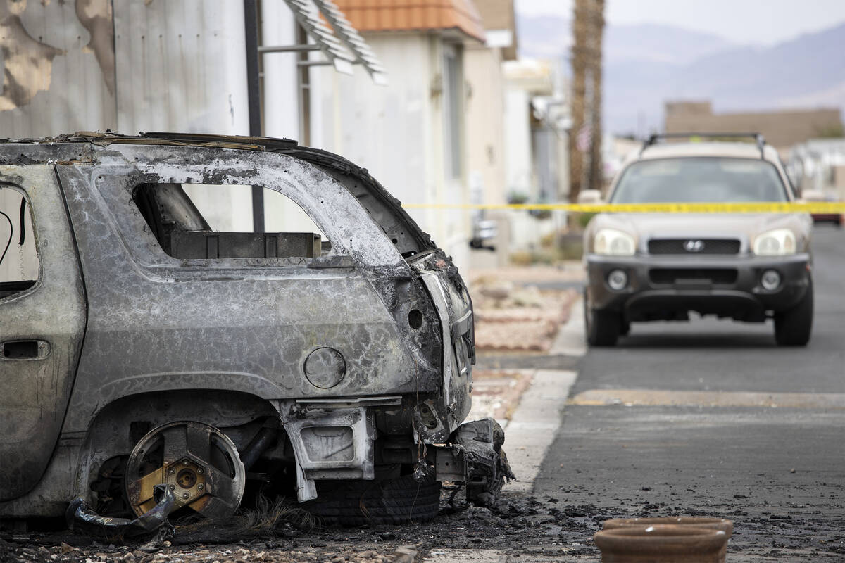 A vehicle is burned at the scene of a fire where two people were found dead at Royal Mobile Hom ...
