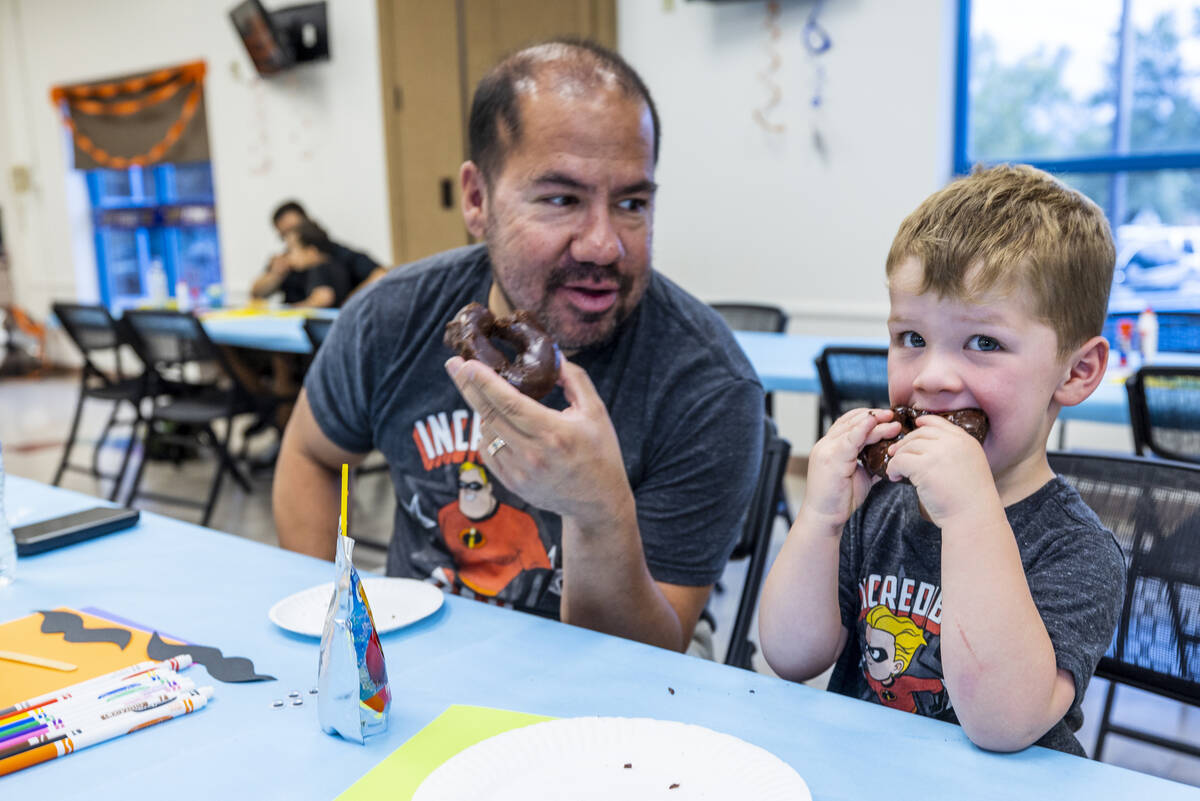 Patrick Arizmendi shares donuts with his son Benjamin, 2, as the City of Henderson celebrates F ...