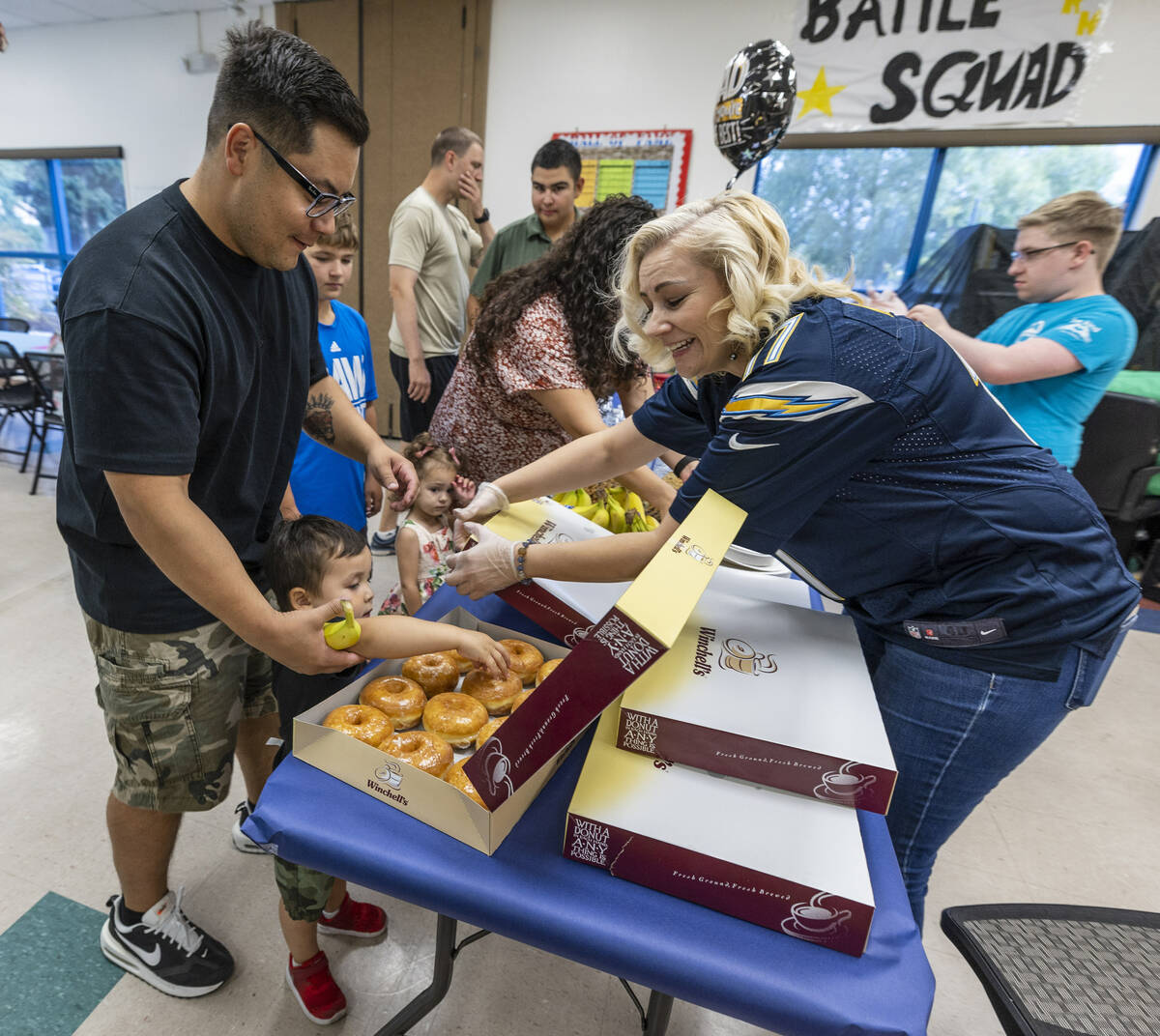 (From left) Peter Hyun looks down to see his son Leo, 2, make his own donut selection as Daniel ...