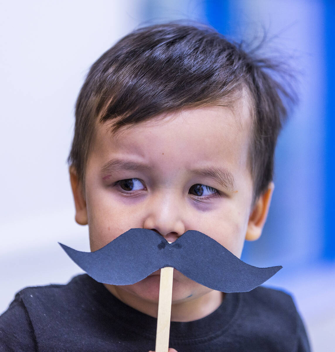 Leo Hyun, 2, is a bit unsure of a large, paper mustache under his nose placed there by his fath ...