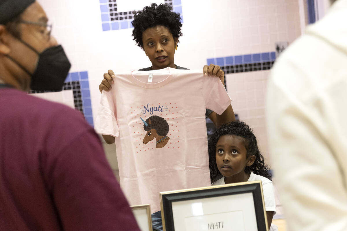 Rahwa Ghebecristos and her daughter Ellie Haddish, 7, speak with customers while showing off th ...