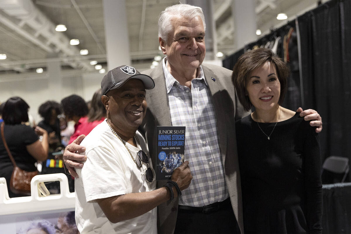 Mickey Frazier, a local author, left, poses for a photo with Gov. Steve Sisolak and his wife Ka ...
