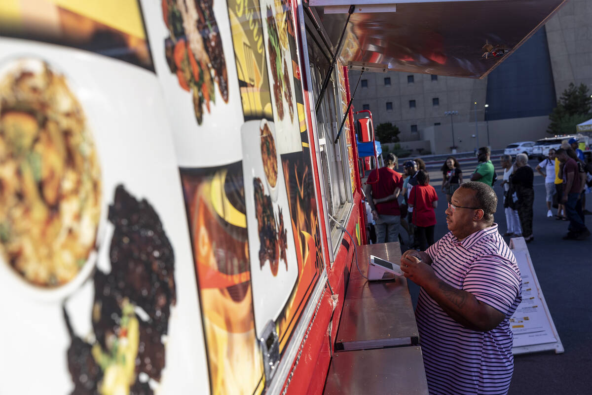 Patrons wait in line for food vendors, including at Braise & Grill Caribbean Fusion, during ...