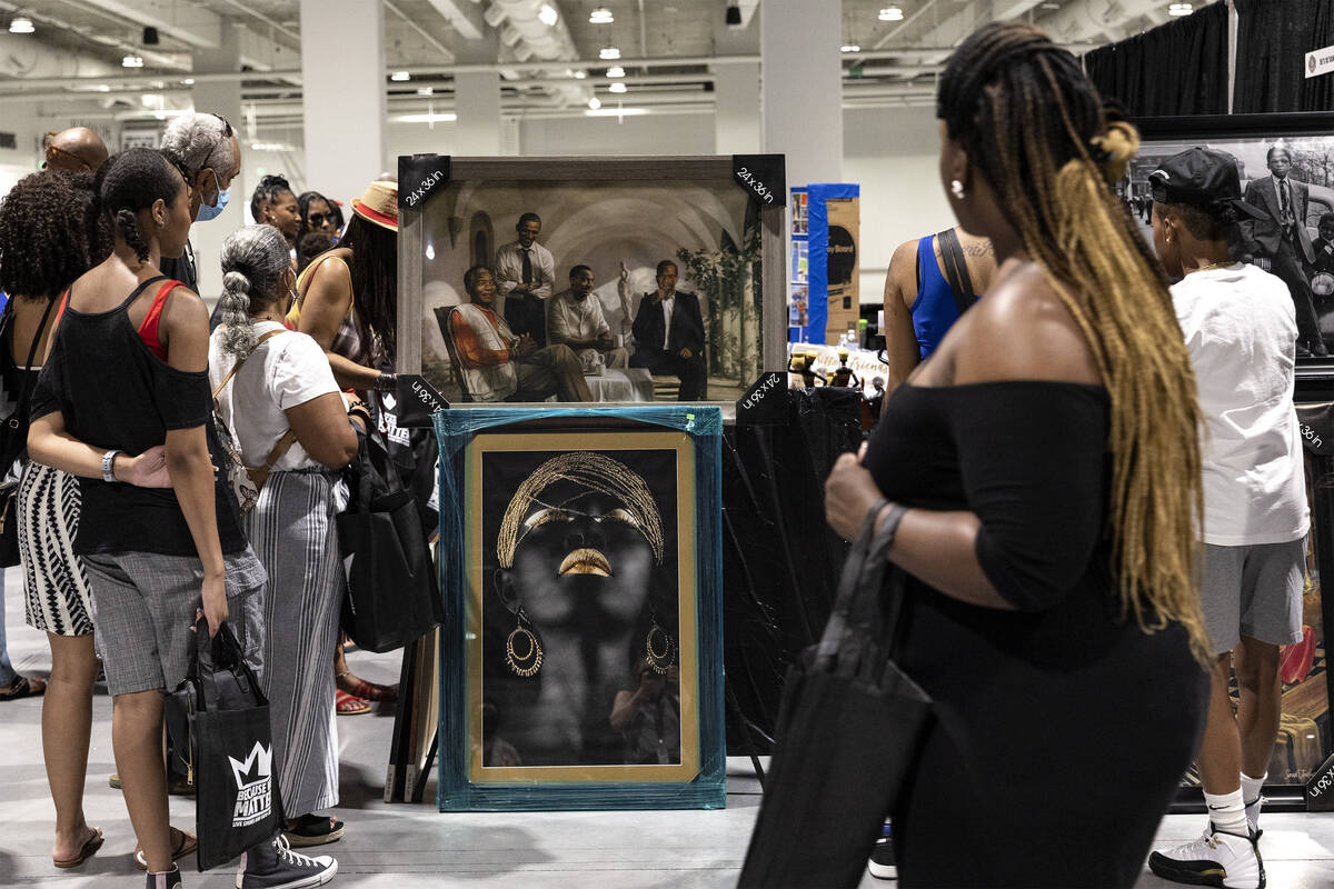 Attendees of a Juneteenth expo view art that is for sale at World Market Center on Saturday, Ju ...