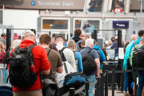 FILE - Travelers queue up at the north security checkpoint in the main terminal of Denver Inter ...
