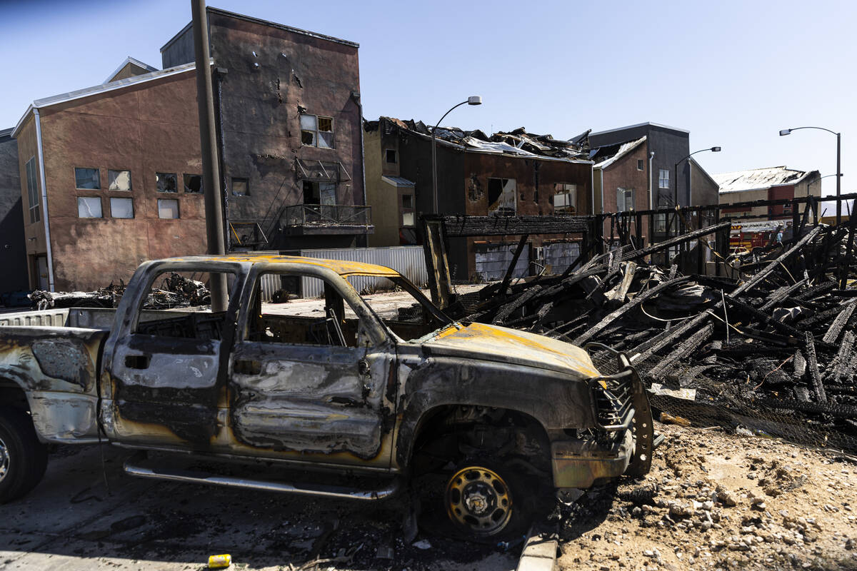 A burned-out truck is pictured at the scene where a fire damaged or destroyed at least 10 build ...
