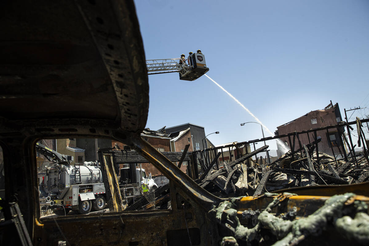 Las Vegas firefighters put out hotspots at the scene where a fire damaged or destroyed at least ...