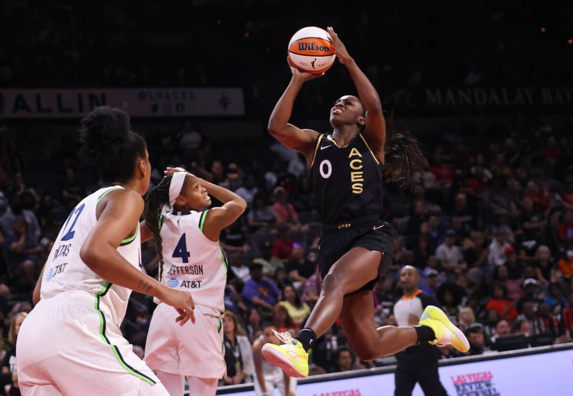 Las Vegas Aces guard Jackie Young (0) shoots past Minnesota Lynx guard Moriah Jefferson (4) dur ...