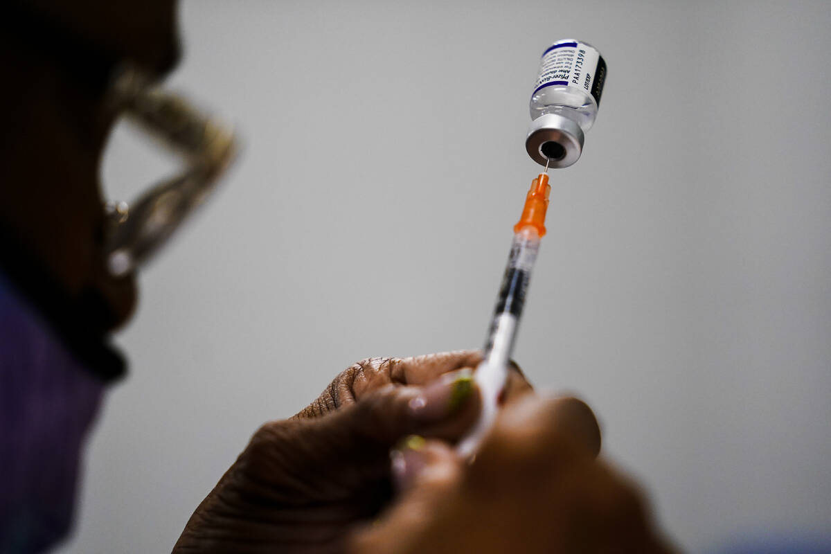 A syringe is prepared with the Pfizer COVID-19 vaccine at a vaccination clinic at the Keystone ...