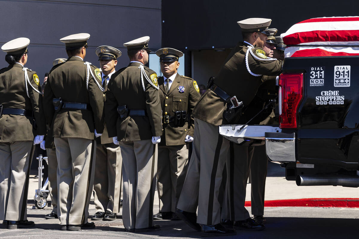 A Metropolitan Police Department honor guard unloads the casket of Las Vegas police Detective J ...