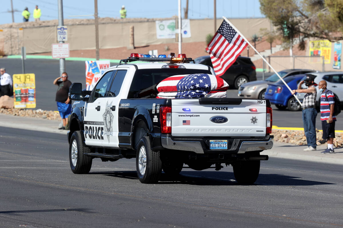 People watch a procession for Las Vegas police Detective Justin Terry at Palm Downtown Mortuary ...