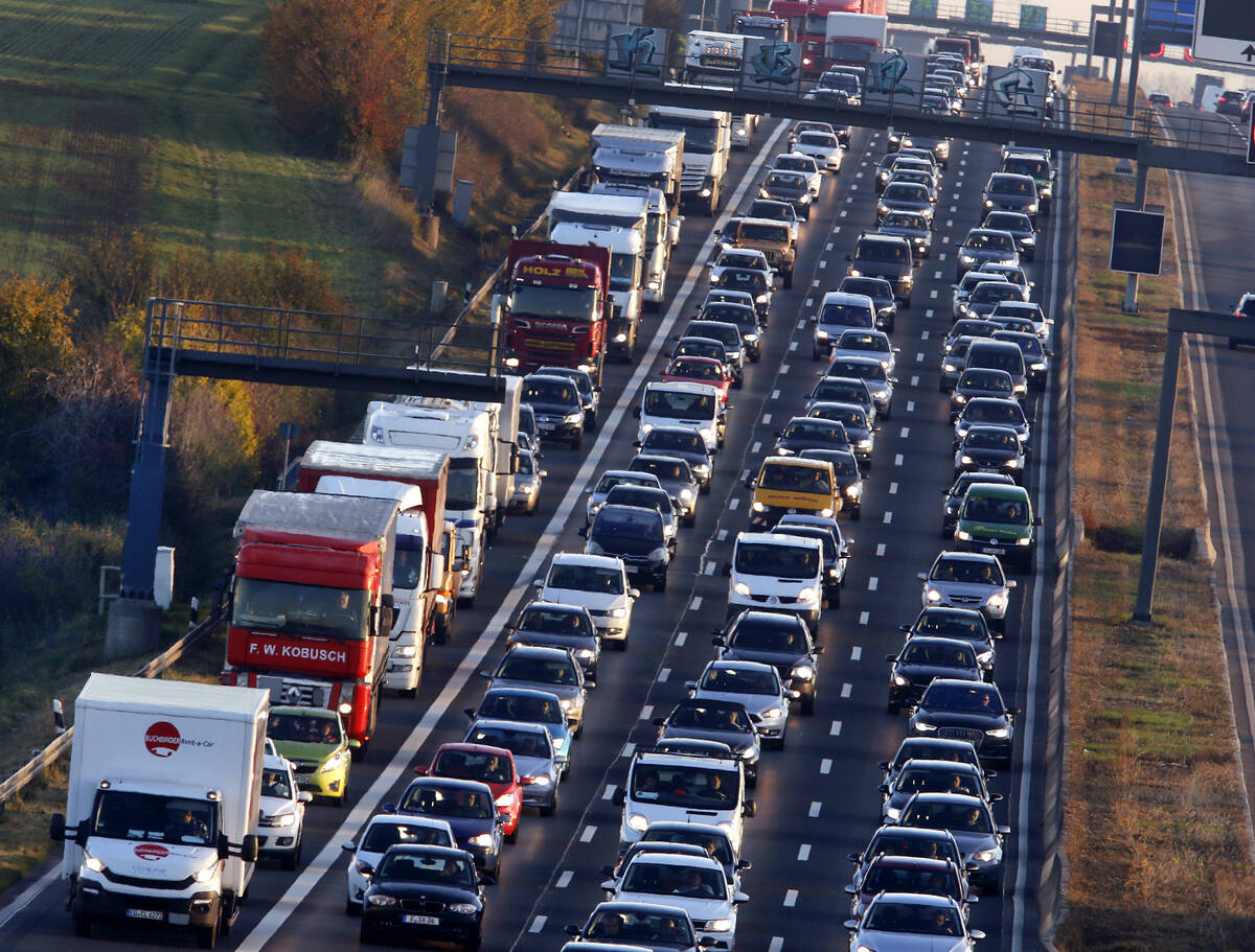 FILE - Cars and trucks queue on the highway A5 in Frankfurt, Germany Nov. 6, 2017. People acros ...