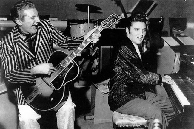 Liberace memainkan gitar sementara Elvis Presley memainkan piano pada November 1956 di Riviera H ...