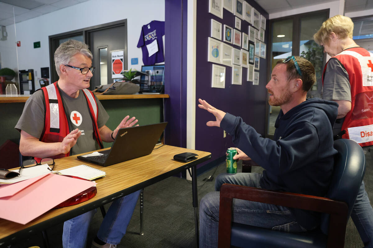 American Red Cross of Southern Nevada volunteer Ben Bishop helps displaced resident Bill Monnet ...