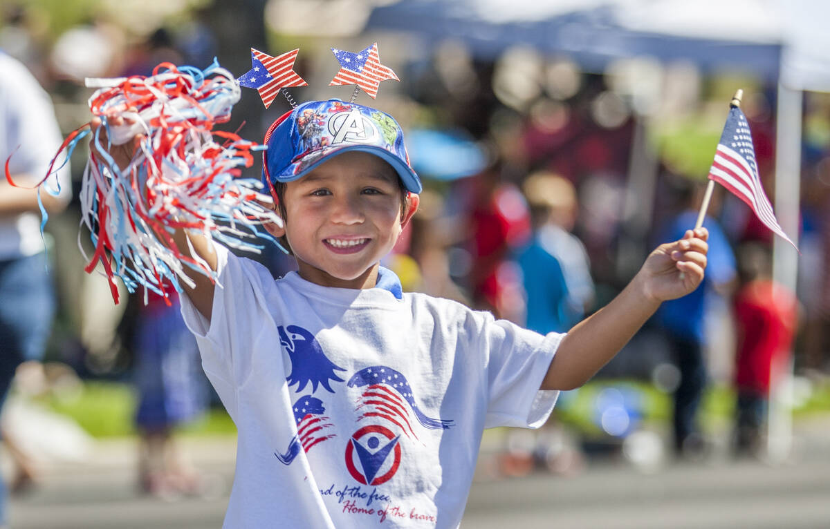In this July 4, 2017, file photo, a young parade goer waves to crowds as he marches in the para ...